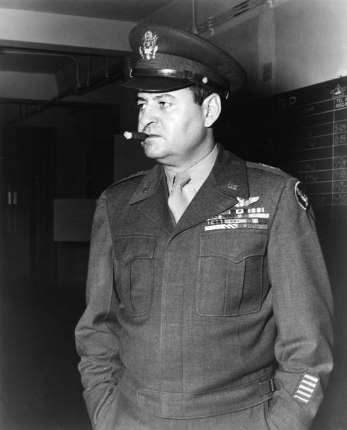 A man smoking a cigar in uniform.