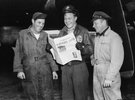 Three US soldiers are reading the US newspaper Stars & Stripes. The end of the blockade is on the cover.