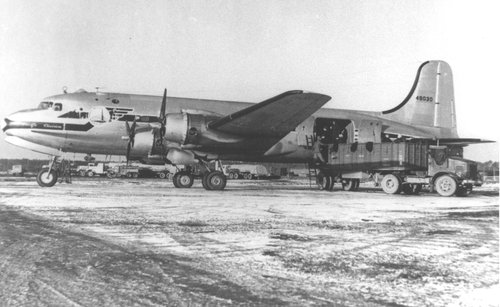 A large cargo plane is being loaded with coal.