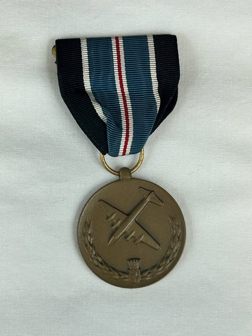 Eine C-54 Medaille mit einem Band in schwarz, blau und weiß.