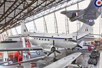 Ein zweimotoriges Flugzeug hängt von der Decke eines Museums mit weiteren Flugzeugen darunter und dahinter.