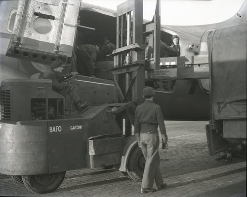 Stahlträger für das Elektrizitätskraftwerk Reuter werden mithilfe eines Gabelstaplers aus einer britischen Hastings entladen. Flugplatz Gatow, 22. Februar 1949.