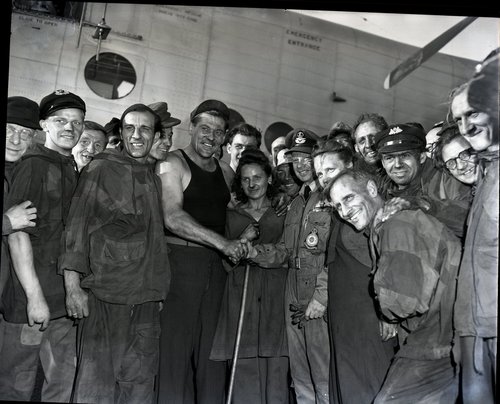 Strahlende Gesichter bei der Entladungsmannschaft und ein Händedruck für den Piloten des letzten York-Luftbrückenflugs von Wunstorf nach Gatow am 26. August 1949