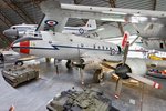 Ein in einem Museum ausgestelltes, viermotoriges Transportflugzeug mit weiteren ausgestellten Flugzeugen im Hintergrund.