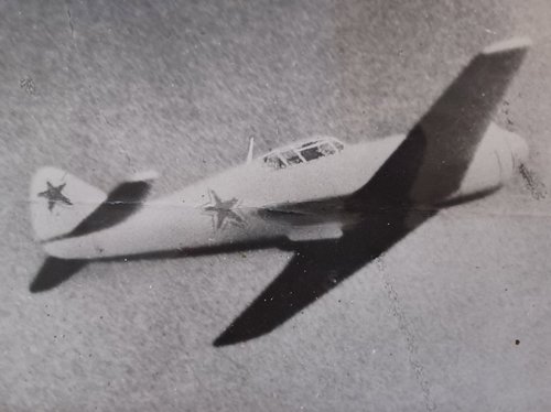 Single-engined fighter aircraft in the air, with star emblems on the side and tail.