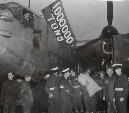 A group of people next to a large transport aeroplane.