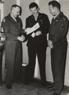 Three men looking at a cartoon.