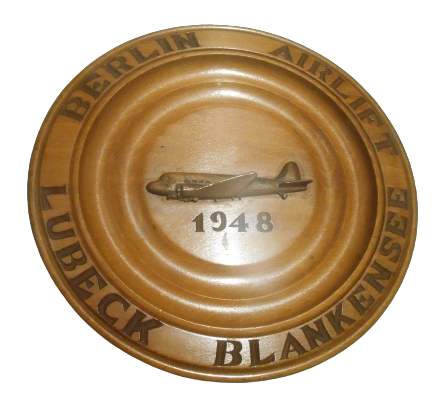 Holzteller, der mit der Innschrift Berlin Airlift  Lübeck Blankensee an die Flüge von Lübeck nach Berlin im Jahre 1948 erinnert.