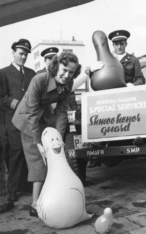 Pilots and a flight attendant present the inflated Shmoo-shaped balloons at Rhein/Main airport.